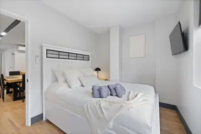 a white bedroom with a bed with two towels on it at Luxury Brand New 3BED Gem 20 Minutes to NYC in Jersey City