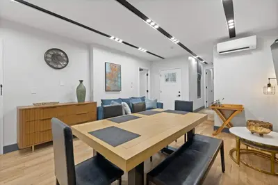 a dining room and living room with a table and chairs at Luxury Brand New 3BED Gem 20 Minutes to NYC in Jersey City