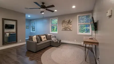 a living room with a couch and a ceiling fan at Luxe Lakefront Paradise! King Beds, Private Dock, Gourmet Kitchen, Theatre and Game Room!