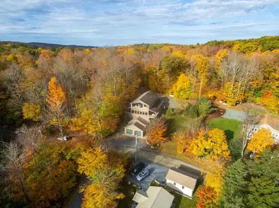 an aerial view of a house in the woods at Luxe Lakefront Paradise! King Beds, Private Dock, Gourmet Kitchen, Theatre and Game Room!