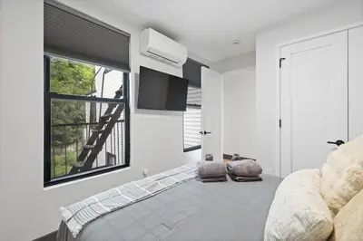 a bedroom with a bed and a flat screen tv at Luxury and Trendy 3BR 2BA APT only 20 minutes to New York in Jersey City