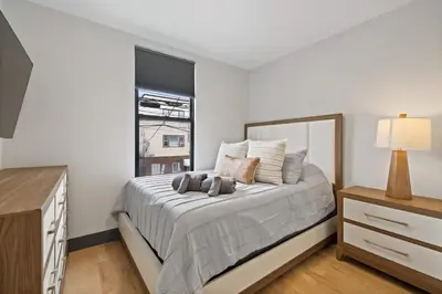 a white bedroom with a bed and a window at Luxury and Trendy 3BR 2BA APT only 20 minutes to New York in Jersey City