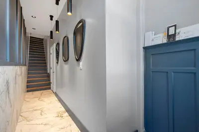 a hallway with a blue door and a staircase at Luxury and Modern Apt with Patio only 10 Min to Times Square in Jersey City