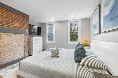 a bedroom with a bed and a brick wall at Luxury and Chic 2BR 2BA Apt only 15 Mins to NYC & Hoboken in Jersey City