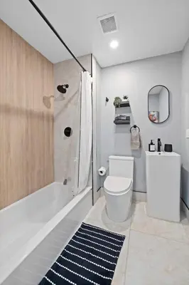 a bathroom with a white toilet and a shower at Luxury and Chic 2BR 2BA Apt only 15 Mins to NYC & Hoboken in Jersey City