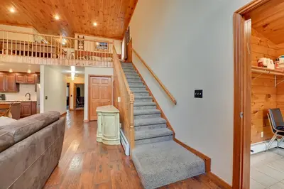 a living room with a staircase in a house at Walk to Hunter Village! Family Ski Retreat with Deck in Lanesville