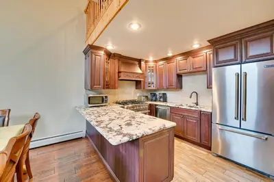 a kitchen with wooden cabinets and a refrigerator at Walk to Hunter Village! Family Ski Retreat with Deck in Lanesville