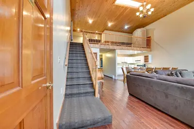 a living room with a staircase and a couch at Less Than 1 Mi to Hunter Mtn Skiing Family-Friendly Stay! in Lanesville
