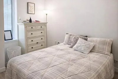 a bedroom with a bed and a dresser with a window at Stylish Downtown Brooklyn Apartment Near Subway & Manhattan in Brooklyn