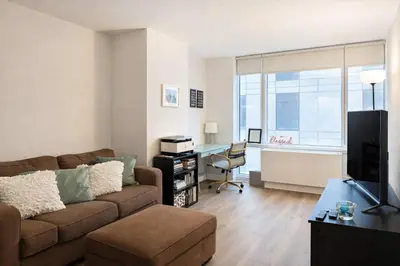 a living room with a couch and a desk at Stylish Downtown Brooklyn Apartment Near Subway & Manhattan in Brooklyn