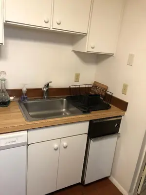 a kitchen with a stainless steel sink and white cabinets at Lakeridge Litchfield townhouse pool tennis skiing in Torrington