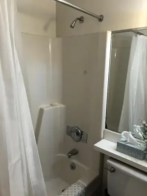 a white bathroom with a shower and a mirror at Lakeridge Litchfield townhouse pool tennis skiing in Torrington