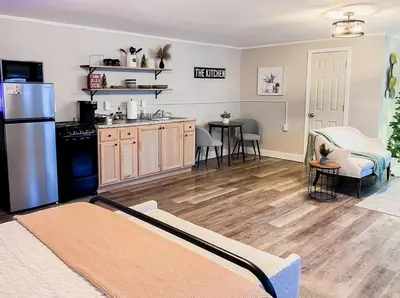 a kitchen and living room with a refrigerator and a table at Modern Cozy Studio in East Windsor