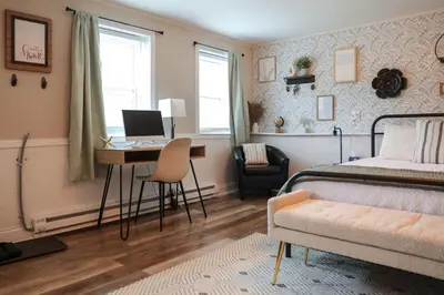 a bedroom with a bed and a desk with a computer at Modern Cozy Studio in East Windsor