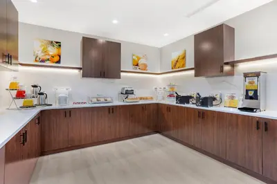 a large kitchen with wooden cabinets and appliances at Comfort Suites Central Valley - Woodbury in Central Valley