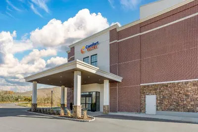 a brick building with a sign on it at Comfort Suites Central Valley - Woodbury in Central Valley