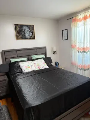 a bedroom with a bed with a black comforter at Private Room 15 Mins to Times Square NYC in West New York