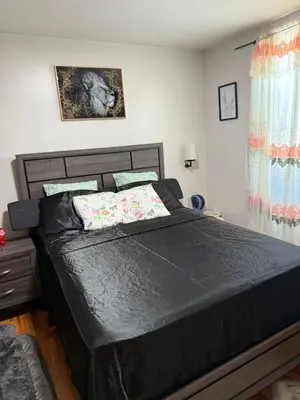 a bedroom with a bed with a black comforter at Private Room 15 Mins to Times Square NYC in West New York