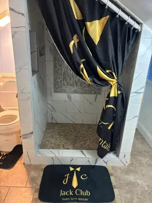 a shower with a black and yellow shower curtain at a whole house in Schenectady