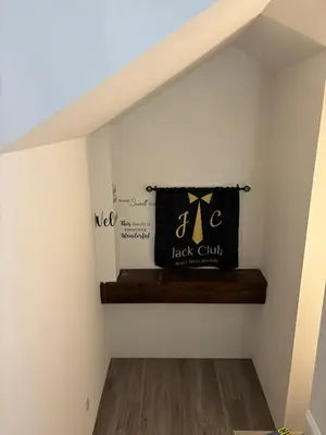 a shelf under the stairs with a black child bag at a whole house in Schenectady