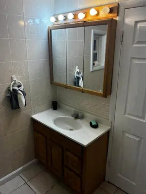a bathroom with a sink and a mirror at a whole house in Schenectady