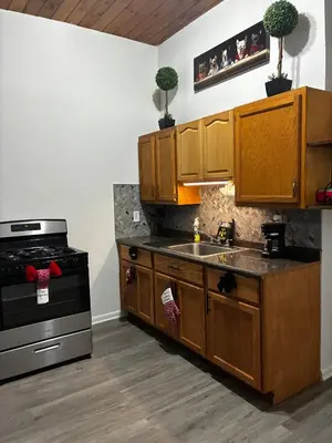 a kitchen with wooden cabinets and a stove at a whole house in Schenectady