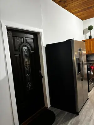 a black door in a kitchen with a refrigerator at a whole house in Schenectady