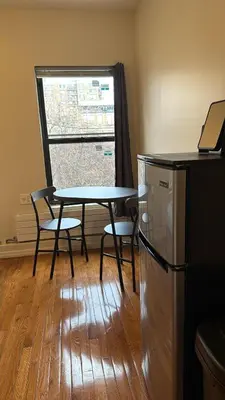 a table and chairs in a room with a window at New York City Guesthouse 3 in New York