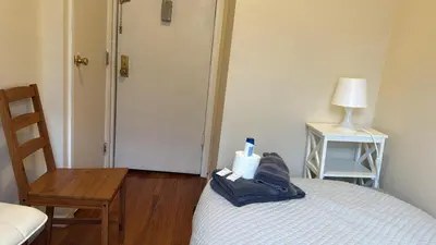 a bedroom with a bed with a chair and a table at New York City Guesthouse 3 in New York