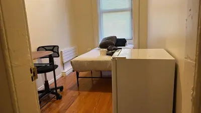 a room with a bed and a desk with a chair at New York City Guesthouse 3 in New York
