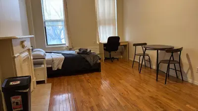 a bedroom with a bed and a table and chairs at New York City Guesthouse 3 in New York