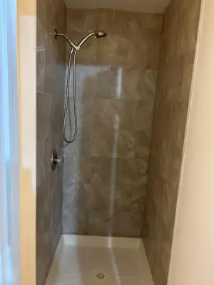 a shower with a shower head in a bathroom at 1BR Apartment - Unit A - With Parking and 10min Walk to NYC Train Station in Mount Vernon