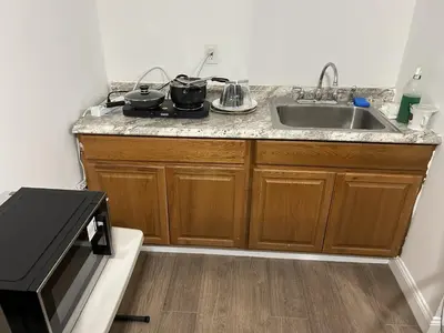 a kitchen counter with a sink and a microwave at 1BR Apartment - Unit A - With Parking and 10min Walk to NYC Train Station in Mount Vernon