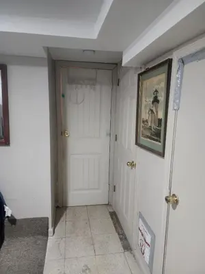 a hallway with a white door and a picture on the wall at Bridgeport East Main in Bridgeport