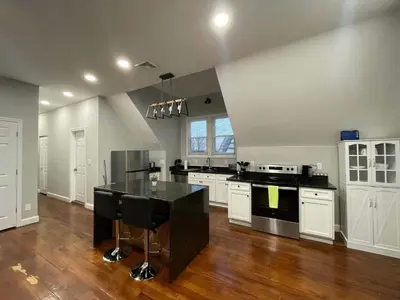 a large kitchen with white cabinets and a black counter top at Apartment in Middletown-Wesleyan 301 in Middletown