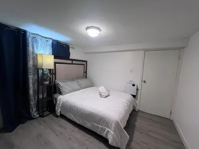 a small bedroom with a bed and a lamp at Entire house for big group-minutes from Hartford in East Hartford