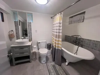 a bathroom with a tub and a toilet and a sink at Entire house for big group-minutes from Hartford in East Hartford