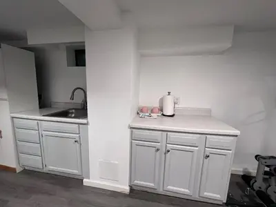 a kitchen with white cabinets and a sink and a counter at Entire house for big group-minutes from Hartford in East Hartford