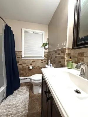 a bathroom with a toilet and a sink and a window at Entire house for big group-minutes from Hartford in East Hartford