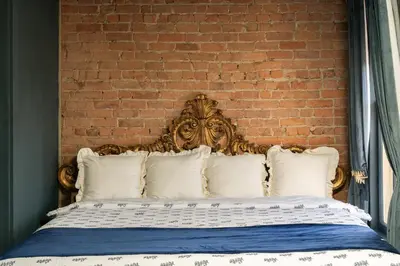a bed with white pillows and a brick wall at The Mulford Alden House in Hudson