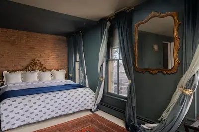 a bedroom with a bed and a mirror at The Mulford Alden House in Hudson
