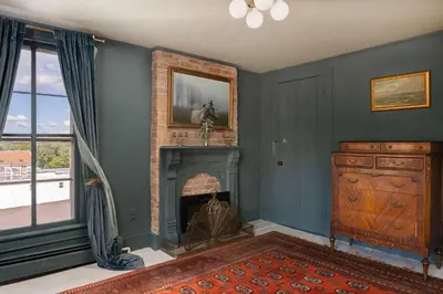 a living room with a fireplace and blue walls at The Mulford Alden House in Hudson