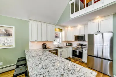 a kitchen with white cabinets and a marble counter top at Catskills Group Getaway on 50 Scenic Acres! in South Kortright