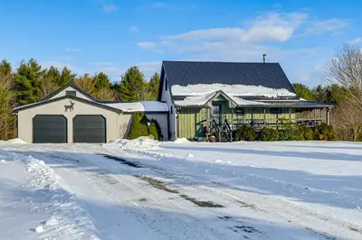 a house with a garage in the snow at Catskills Group Getaway on 50 Scenic Acres! in South Kortright