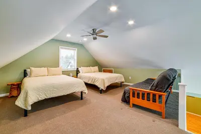 a attic room with two beds and a ceiling fan at Catskills Group Getaway on 50 Scenic Acres! in South Kortright
