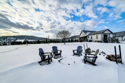 four chairs in the snow in front of a house at Catskills Group Getaway on 50 Scenic Acres! in South Kortright