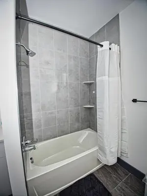 a bathroom with a white tub and a shower at Luxurious and Spacious Apt with Parking 20 min to NYC in West New York