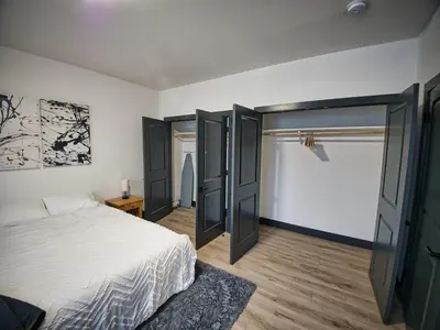 a bedroom with a bed with black doors and a window at Luxurious and Spacious Apt with Parking 20 min to NYC in West New York