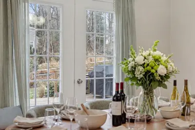 a dining room table with a vase of flowers and wine bottles at The Willowbrook Catskills in Athens