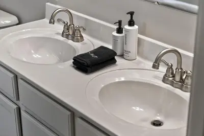 a bathroom sink with two faucets and a black towel at The Willowbrook Catskills in Athens